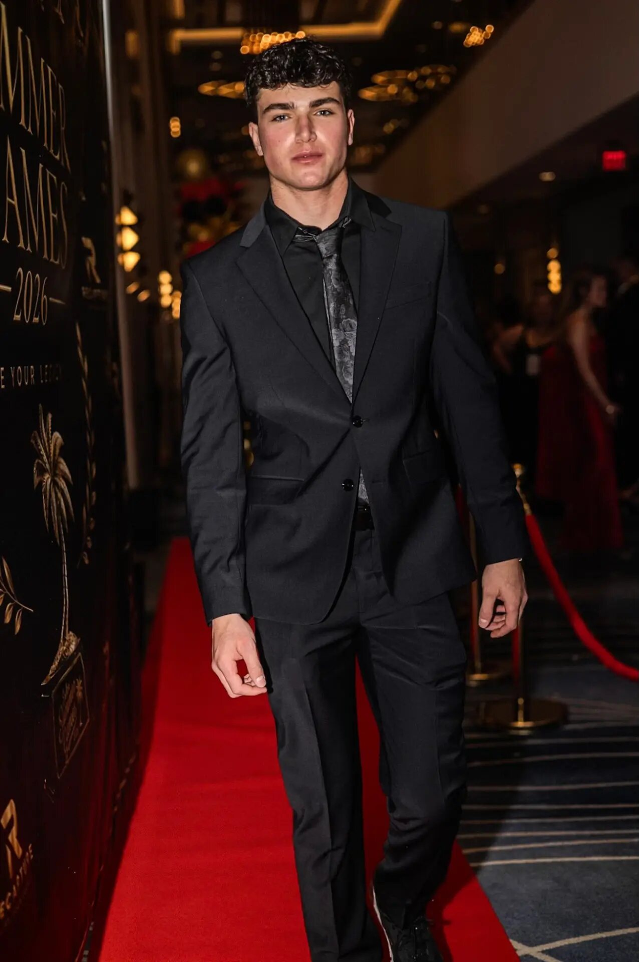 Jaxon Avery in a black suit on a red carpet
